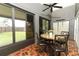 Enclosed patio with tile floors, ceiling fan, windows, and a small table set at 1825 Needham Rd, Apopka, FL 32712