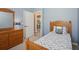 Cozy bedroom featuring a wooden bed frame, blue walls, and a glimpse into the dining area at 1969 Crystal Downs Ct, Oviedo, FL 32765