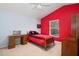 Bedroom featuring a sporty red accent wall, wooden desk, and fan at 1969 Crystal Downs Ct, Oviedo, FL 32765