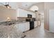 Bright kitchen featuring white cabinets, granite countertops, black appliances, and ample counter space at 1969 Crystal Downs Ct, Oviedo, FL 32765