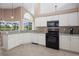 Kitchen featuring white cabinetry, black appliances, and large corner windows with views of the pool and golf course at 1969 Crystal Downs Ct, Oviedo, FL 32765