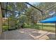 A screened-in patio with brick pavers, and an umbrella with a view of the garden and a golf course at 1969 Crystal Downs Ct, Oviedo, FL 32765