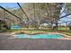 Screened-in pool area with a small waterfall feature, brick pavers, and blue umbrella at 1969 Crystal Downs Ct, Oviedo, FL 32765