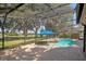 Screened-in pool area with a small waterfall feature, brick pavers, and blue umbrella at 1969 Crystal Downs Ct, Oviedo, FL 32765