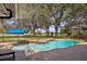Screened-in pool area with a small waterfall feature, brick pavers, and blue umbrella at 1969 Crystal Downs Ct, Oviedo, FL 32765