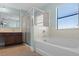Bathroom with a combined shower and tub, dark wood cabinets, and neutral tile at 1978 Fishtail Fern Way, Ocoee, FL 34761