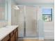 Modern bathroom featuring a shower, tub, vanity, and a window with natural light at 1978 Fishtail Fern Way, Ocoee, FL 34761