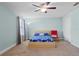 Bright bedroom featuring a ceiling fan, a modern bed frame, and a cozy reading chair at 1978 Fishtail Fern Way, Ocoee, FL 34761