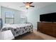 Bedroom with a ceiling fan, large windows, dresser, and TV at 1978 Fishtail Fern Way, Ocoee, FL 34761
