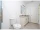 Bright bathroom with a toilet, double sink vanity featuring a granite top, and a white door at 2024 Sw 153Rd Loop, Ocala, FL 34473