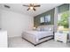 Well-lit bedroom with neutral tones, ceiling fan, and minimalist decor creating a relaxing atmosphere at 2024 Sw 153Rd Loop, Ocala, FL 34473