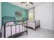 Bright bedroom features a teal accent wall, two twin beds, and a window with natural light at 2024 Sw 153Rd Loop, Ocala, FL 34473
