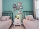 Charming bedroom featuring twin beds, teal accent wall, and stylish art decor at 2024 Sw 153Rd Loop, Ocala, FL 34473