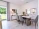 Dining area with modern table, gray chairs, sliding glass doors, and stylish mirror decoration on the wall at 2024 Sw 153Rd Loop, Ocala, FL 34473