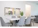 Contemporary dining room with a white table, gray chairs, and a decorative mirror reflecting the kitchen at 2024 Sw 153Rd Loop, Ocala, FL 34473