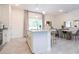White kitchen island with granite countertop, pendant lights, and dining area in an open-concept layout at 2024 Sw 153Rd Loop, Ocala, FL 34473