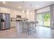 Bright kitchen featuring stainless steel appliances, granite countertops, a kitchen island, and stylish bar stools at 2024 Sw 153Rd Loop, Ocala, FL 34473