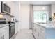 Bright kitchen featuring white cabinets, stainless steel appliances, and a sink with a pull-down faucet at 2024 Sw 153Rd Loop, Ocala, FL 34473