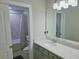 Well-lit bathroom featuring a modern vanity and tub with tiled wall accents at 2539 Auburn Ridge Dr, Apopka, FL 32712