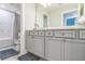 Bathroom featuring gray cabinets, modern fixtures, and a shower/tub combination at 2539 Auburn Ridge Dr, Apopka, FL 32712