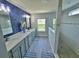 Modern bathroom with dual sinks, a luxurious walk-in shower and stylish blue wallpaper at 2539 Auburn Ridge Dr, Apopka, FL 32712