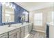 Bright bathroom features dual sinks, gray cabinetry, quartz counters, and decorative blue accent wall at 2539 Auburn Ridge Dr, Apopka, FL 32712