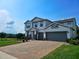 View of a two-story home with an attached two-car garage, complimented by a brick driveway at 2539 Auburn Ridge Dr, Apopka, FL 32712
