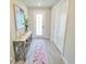 Hallway with decorative rug and matching table, illuminated by natural light from the glass door at 2539 Auburn Ridge Dr, Apopka, FL 32712