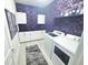 Well-organized laundry room with damask wallpaper, white cabinets, counter space, washer, and dryer at 2539 Auburn Ridge Dr, Apopka, FL 32712