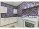 Well-equipped laundry room with decorative wallpaper, shelving and cabinets for ample storage at 2539 Auburn Ridge Dr, Apopka, FL 32712