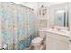 Well-lit bathroom features a floral shower curtain, modern vanity, and storage cabinet at 26271 Feathergrass Cir, Leesburg, FL 34748