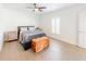 Bright bedroom has hardwood floors, a comfortable bed, and natural light from the window at 26271 Feathergrass Cir, Leesburg, FL 34748