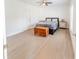 Cozy bedroom boasts hardwood floors, a comfy bed, and natural light at 26271 Feathergrass Cir, Leesburg, FL 34748