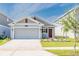 Charming single-story home featuring a gray facade, well-maintained landscaping, and an attached two-car garage at 26271 Feathergrass Cir, Leesburg, FL 34748