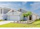 Single-story home featuring a gray facade, well-maintained landscaping, and a two-car garage at 26271 Feathergrass Cir, Leesburg, FL 34748