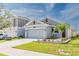Charming single-story home featuring a gray facade, well-maintained landscaping, and an attached two-car garage at 26271 Feathergrass Cir, Leesburg, FL 34748