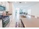 Modern open-concept kitchen with a large island, stainless steel appliances, and views of the adjacent living space at 26271 Feathergrass Cir, Leesburg, FL 34748