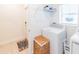 Bright laundry room features a modern washer and dryer, overhead shelving, and tiled floors at 26271 Feathergrass Cir, Leesburg, FL 34748