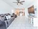 Open-concept living room featuring tile floors, modern furniture, and easy kitchen access at 26271 Feathergrass Cir, Leesburg, FL 34748