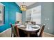 Dining room featuring a modern chandelier, a glass table set for six, and bright light from the window at 2648 Daulby St, Kissimmee, FL 34747