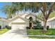 Charming two-story home with a well-maintained lawn, mature trees, and a two-car garage at 2648 Daulby St, Kissimmee, FL 34747