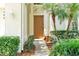 Inviting entryway with a wooden door framed by lush greenery and a charming stone bench at 2648 Daulby St, Kissimmee, FL 34747