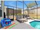 Relaxing screened-in pool area featuring lounge chairs and fun pool toys for a day of fun at 2648 Daulby St, Kissimmee, FL 34747