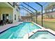 Sparkling pool and spa surrounded by a screened enclosure and seating for entertaining at 2648 Daulby St, Kissimmee, FL 34747