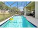 Gorgeous screened in pool with brick patio and a mounted outdoor television for entertaining at 2648 Daulby St, Kissimmee, FL 34747
