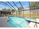 Sparkling pool and spa surrounded by a screened enclosure with plenty of room for lounge chairs at 2648 Daulby St, Kissimmee, FL 34747