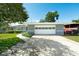 Charming home featuring a large garage, well-manicured lawn, and inviting curb appeal on a sunny day at 2736 Shannon Rd, Orlando, FL 32806