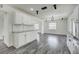 Bright, open kitchen featuring white cabinets, granite countertops, modern lighting, and adjacent sitting area at 2736 Shannon Rd, Orlando, FL 32806