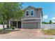 Charming two-story home features a brick driveway, attached garage, screened in porch, and a well-maintained yard at 275 Lakeshore Dr, Davenport, FL 33837
