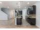 Modern kitchen features an island, stainless steel appliances, granite countertops, and stairs to the next level at 275 Lakeshore Dr, Davenport, FL 33837